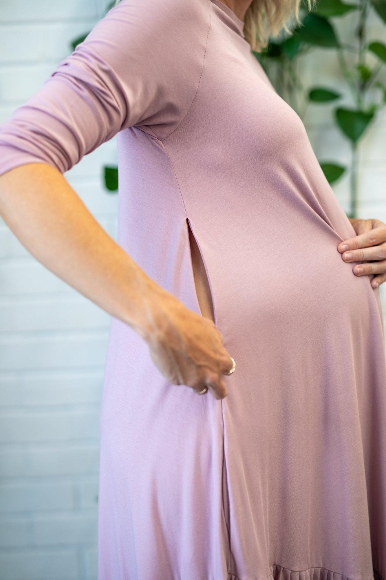 a pregnant lady standing side on pulling a zip down on her side ready for breastfeeding