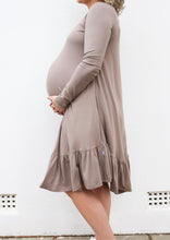 Load image into Gallery viewer, Side view of a pregnant lady holding her baby bump in a dress
